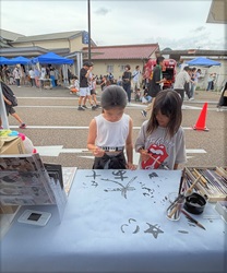 子どもが水書板で熊野筆を試す様子